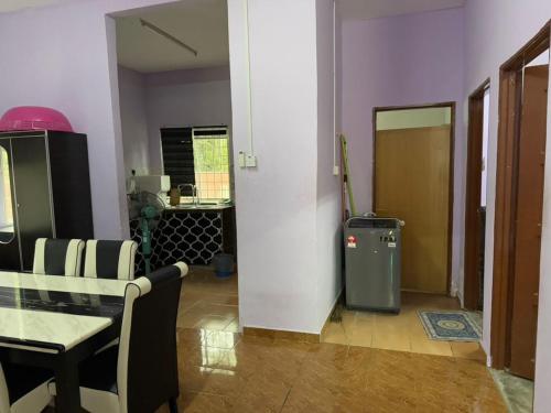 a living room with a table and a trash can at Aliza Scawa Homestay in Kuala Pilah