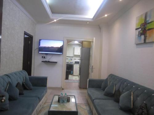 a living room with couches and a flat screen tv at العين الهيلي مصباح بيت 5 in Al Ain