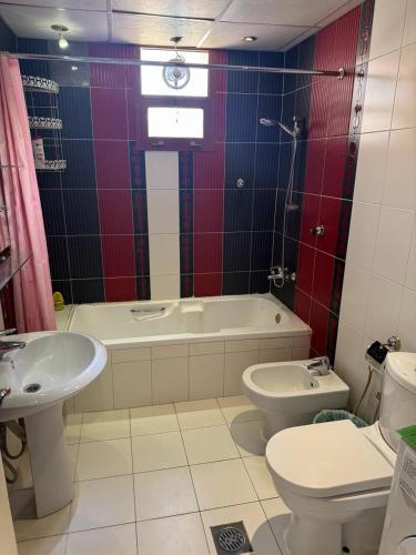 a bathroom with a tub and a toilet and a sink at العين الهيلي مصباح بيت 5 in Al Ain