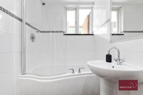 a white bathroom with a sink and a shower at Richmond Three Bedroom Flat in Whitton