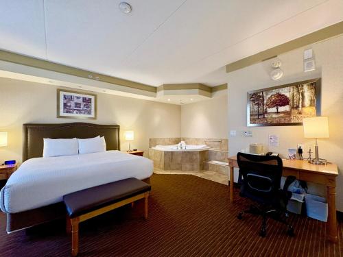 une chambre d'hôtel avec un lit et une baignoire dans l'établissement Waterloo Suites Hotel, Trademark Collection by Wyndham, à Waterloo