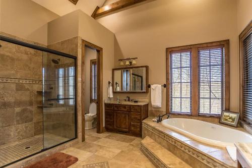 Un baño con bañera, ducha y lavabo. en Elk Camp Lodge, en Linville