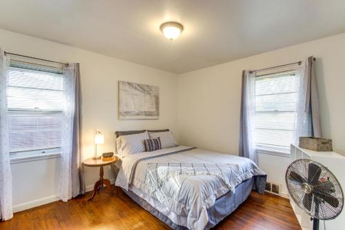 1 dormitorio con 1 cama, ventilador y 2 ventanas en Easy OKC Access! Quiet Home with Yard and Workspace, en Midwest City