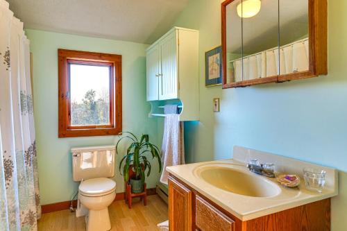 Un baño con lavabo, inodoro y ventana. en Relaxation Meets Upstate Adventure at Salem Home!, en Rupert