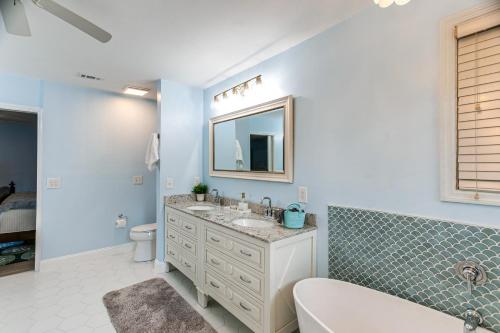 a bathroom with a sink and a toilet and a mirror at 4 Mi to St Simons Beach Modern Getaway with Sunroom in Blackbanks