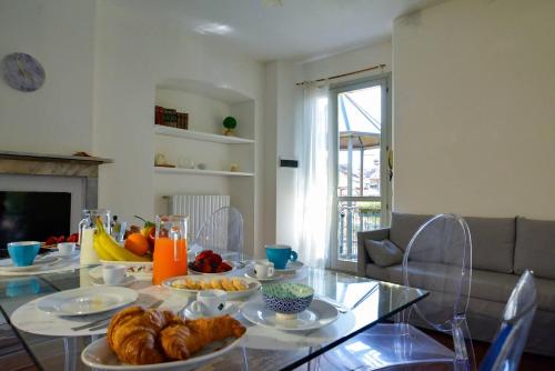 a table with plates of food on it in a living room at Timeless Garden Lake Como in Gravedona