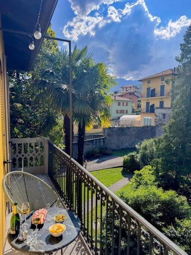 a table with food and drinks on a balcony at Timeless Garden Lake Como in Gravedona