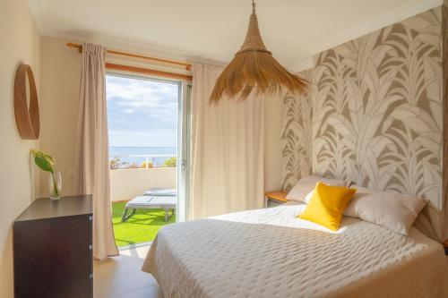 una camera da letto con un letto e una grande finestra di Peace Rooftop Tenerife a Tabaiba