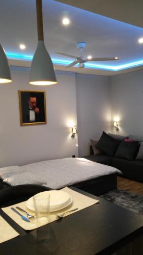 a bedroom with a bed and a table with a plate on it at A3XD Apartament in Częstochowa