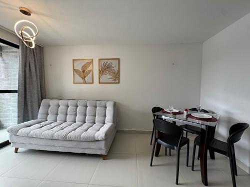 a living room with a couch and a table at Dutra Ocean · Apartamento completo próximo à praia com academia in Mongaguá