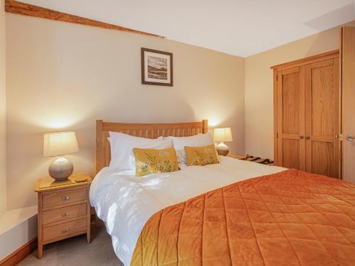 ein Schlafzimmer mit einem großen Bett mit zwei Kissen in der Unterkunft The Old Rectory Cottages - Six Luxurious Cottages Set In Grounds With Indoor Pool in Kings Nympton