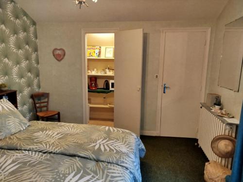 - une chambre avec un lit et une porte menant à une cuisine dans l'établissement Chambre d hôte de la paix, à La Rochefoucauld