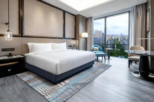 a hotel room with a bed and a large window at Crowne Plaza Hangzhou Linping by IHG in Hangzhou