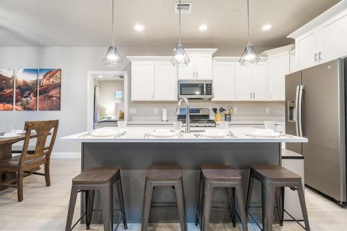 a kitchen with a large island with bar stools at Zion Village Poolhouse in Hurricane with Pool and Hot Tub in Hurricane