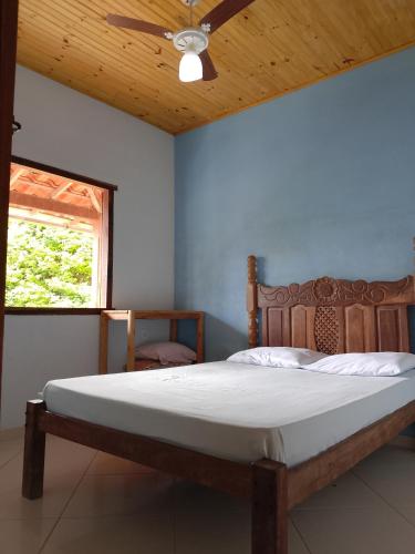 a bedroom with a bed with a ceiling fan and a window at hospedagem- Bela Vista in Milho Verde