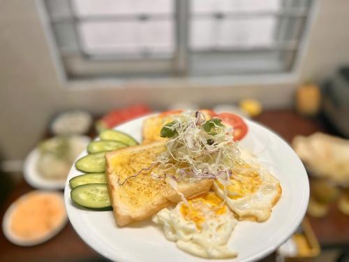 a plate of food with eggs and vegetables on a table at Oanh Thư Hotel in Mèo Vạc