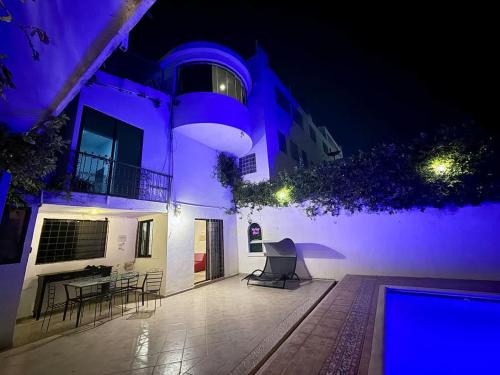 a building with a patio with chairs and a table at Alojamiento para 3 personas con alberca y billar in Chuburná de Hidalgo