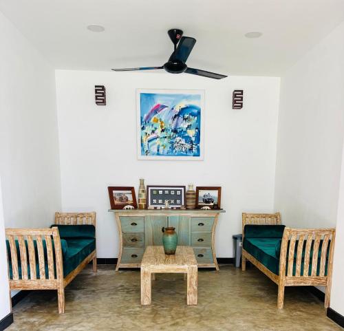 a living room with two chairs and a dresser at Aanya Villa by the Beach in Mirissa