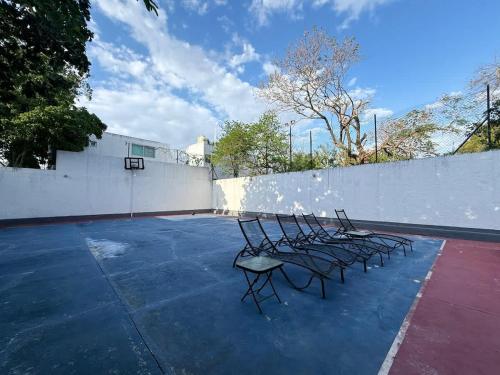 un groupe de chaises assises sur un parking dans l'établissement Loft Alojamiento para 2 Piscina y Billar, à Chuburná de Hidalgo