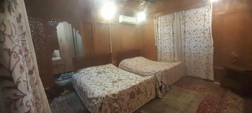 a small bedroom with two beds and a mirror at House boat MASHAL in Srinagar