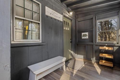 a room with a bench and two windows at Current Cottage Waterside 1 Bed 1 Ba Private Pond in Bradford