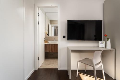 een wit bureau met een stoel en een tv aan de muur bij Villa Casa Minerva in Majkusi