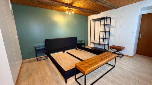 AlpinRetro-Apartment I Stylisch & zentral I See & Berge I Luzern I Zürich I Stoos I Rigi في شويز: أريكة في غرفة مع جدار أخضر