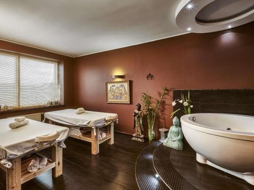 a bathroom with two beds and a bath tub at Mercure Wrocław Centrum in Wrocław