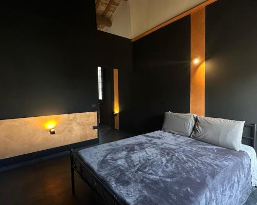 ein Schlafzimmer mit einem Bett und einer schwarzen Wand in der Unterkunft Appartamenti "UNIQUE" palazzo storico FAENZA in Faenza