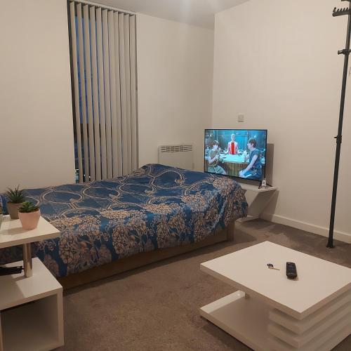 a bedroom with a bed and a flat screen tv at Ensuite Double Bedroom, Live in landlord in Warrington