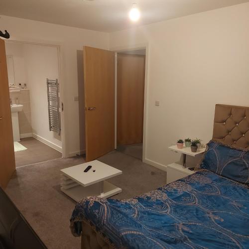a bedroom with a bed and a table and a door at Ensuite Double Bedroom, Live in landlord in Warrington