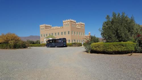 um autocarro estacionado em frente a um grande edifício em hotel and restaurant kasbah draa em Agdz