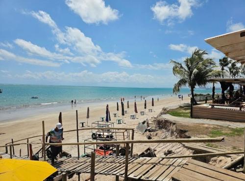 a beach with a group of people and the ocean at Flat perto do MAR in Cabedelo