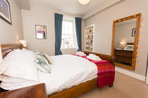 a bedroom with a bed and a large mirror at Luxury New Town 1 Bed Apartment in Edinburgh