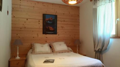 MizoënChalet Limondin的卧室里有一张床，墙是木的