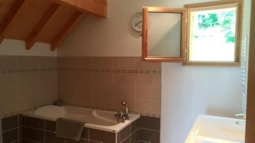 MizoënChalet Limondin的带浴缸、水槽和镜子的浴室