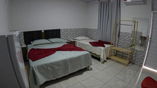 a bedroom with two beds and a mirror at viladowalbinhobarreirinhas in Barreirinhas