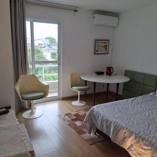 クリチバにあるApartamento residencial inteiroのベッドとテーブルと椅子のある寝室