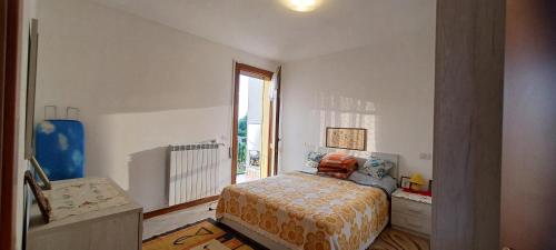 a bedroom with a bed and a large window at Abate Appartament in Correzzola