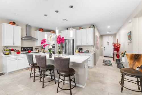 a kitchen with white cabinets and a large island with bar stools at Goodyear Retreat Pool Slide Firepit BBQ in Perryville