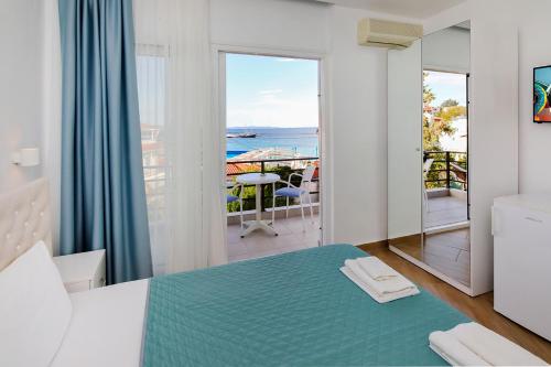 a room with a bed and a view of the ocean at Angelina Hotel in Ormos Panagias