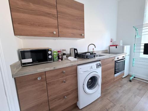 una cocina con lavadora y microondas en Apartment 2- 216 High Street, en Arbroath