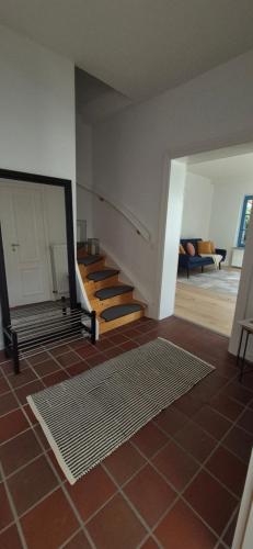 sala de estar con escalera y suelo de baldosa en Altstadt Loog, en Leer