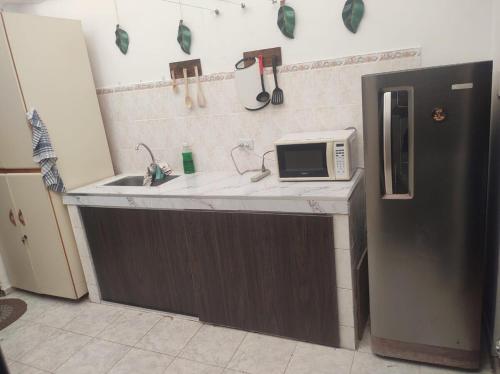 a kitchen with a sink and a microwave on a counter at Nina House, Cali, Valle del Cauca in Cali