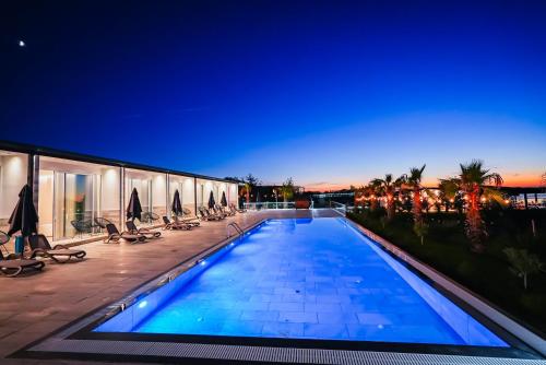 une piscine sur le côté d'un immeuble dans l'établissement Lumeris lakeview Suites and SPA, à Rubjekë