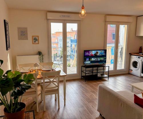 ル・ブラン・メニルにあるApartment in Paris Suburb, 15 minutes to center.のテーブルとテレビのあるリビングルーム