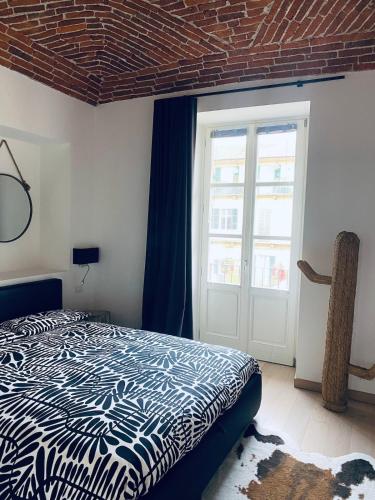 a bedroom with a bed and a large window at CASA JACK Open Space Piazza Galimberti in Cuneo