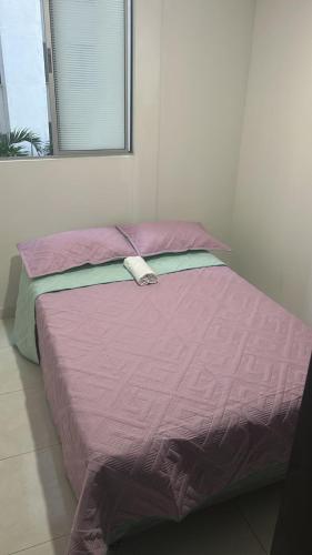 a bed with a purple comforter in a room at Apartamento Silver Park in Cúcuta