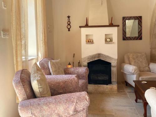 a living room with two chairs and a fireplace at Levanda House - Traditional House in Vasa Kilaniou