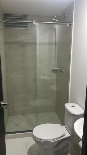 a bathroom with a toilet and a glass shower at Apartamento Silver Park in Cúcuta